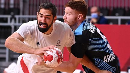 Nikola Karabatic tente de s'extirper de la défense argentine lors du premier match des Bleus, le 24 juillet.&nbsp; (MARTIN BERNETTI / AFP)