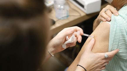 Une femme reçoit une dose de vaccin contre le Covid-19, dans une pharmacie d'Ajaccio, le 5 octobre 2023. (PASCAL POCHARD-CASABIANCA / AFP)