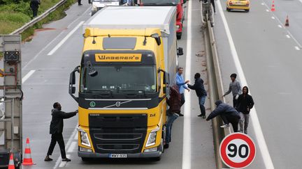 Des migrants tentent de pénétrer dans un camion en direction de l'Angleterre, le 20 juin 2016 à Calais. (MAXPPP)