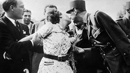 6 août 1944 – Une Parisienne manifeste sa joie en embrassant le général De Gaulle, sur les Champs-Elysées, lors du défilé après la Libération de la capitale.&nbsp; (AFP)