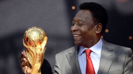 L'ancien joueur br&eacute;silien de football Pel&eacute;, dimanche 9 mars 2014 devant l'H&ocirc;tel de ville &agrave; Paris, avec le troph&eacute;e de la Coupe du monde. (FRANCK FIFE / AFP)