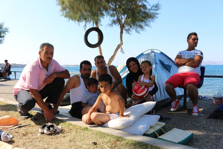 Ibrahim, migrant syrien (deuxi&egrave;me &agrave; gauche), avec ses amis et ses enfants devant leur tente sur le bord de mer de Kos (Gr&egrave;ce), le 19 ao&ucirc;t 2015. (BENOIT ZAGDOUN / FRANCETV INFO)