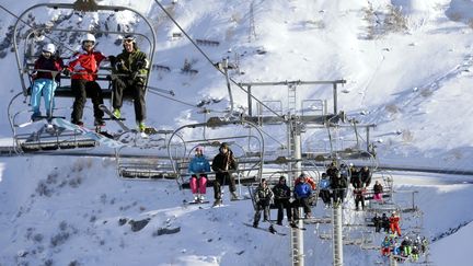 Des skieurs prennent un télésiège dans les Alpes françaises, en février 2014 (image d'illustration) (Illustration/PHILIPPE DESMAZES / AFP)