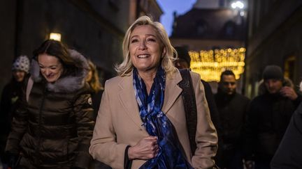 La&nbsp;candidate du Rassemblement national Marine Le Pen marche dans les rues de la vieille ville de Varsovie, en Pologne, le 3 décembre 2021. (WOJTEK RADWANSKI / AFP)