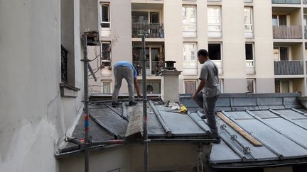 José et ses collègues montent un échafaudage de cinq étages dans une cour d'immeubles alors que le thermomètre affiche 38°C. (RADIO FRANCE / MATHILDE LEMAIRE)