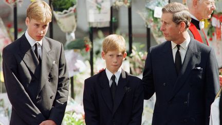 SEPTEMBRE 1997 - La princesse Diana est morte dans un accident de voiture, à Paris, le 31 août 1997. Elle a été inhumée le 6 septembre suivant, à Londres. Le prince Harry (au centre), qui avait alors 12 ans, a été dévasté par ce drame . "Ma façon de faire face à ça a été de pratiquer la 'politique de l'autruche', de refuser de penser à ma mère, car en quoi cela pouvait-il m'aider ? Cela pouvait juste me rendre triste, cela n'allait pas me la ramener", a-t-il confié au quotidien britannique "The Telegraph", en avril 2017. (JEFF J MITCHELL UK / AFP)