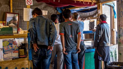 Des migrants font la queue dans un restaurant de la "jungle", à Calais (Pas-de-Calais), le 12 août 2016. (PHILIPPE HUGUEN / AFP)