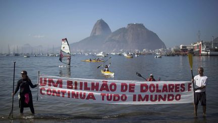 Des manifestants d&eacute;ploient une banni&egrave;re d&eacute;non&ccedil;ant le manque de mobilisation des autorit&eacute;s contre la pollution des eaux &agrave; Rio (Br&eacute;sil), le 6 juin 2015.&nbsp; (FELIPE DANA / AP / SIPA)