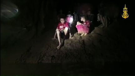 Les enfants portés disparus pendant plus d'une semaine au fond d'une grotte de la province de Chiang Rai, en Thaïlande, filmés par un plongeur le 2 juillet 2018, jour où ils ont été retrouvés. (HO / ROYAL THAI NAVY / AFP)