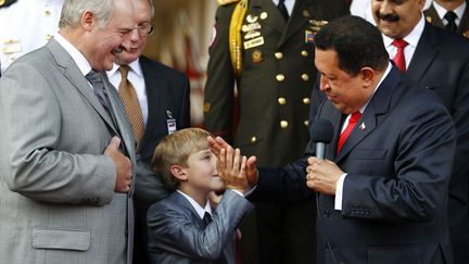 Alexandre emmène Kolia lors de ses visites à l’étranger, comme ici au Venezuela le 26 juin 2012 au palais de Miraflores à Caracas. On en profite pour saluer «à la djeunes» l’homologue vénézuélien de Loukachenko, Hugo Chavez (mort le 5 mars 2013).
 (REUTERS - Carlos Garcia Rawlins)