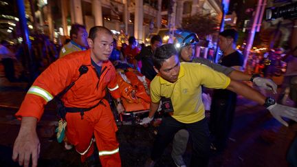 Les premiers sauveteurs transportent une bless&eacute; apr&egrave;s l'explosion d'une bombe &agrave; Bangkok le 17 ao&ucirc;t 2015.&nbsp; (PORNCHAI KITTIWONGSAKUL / AFP)