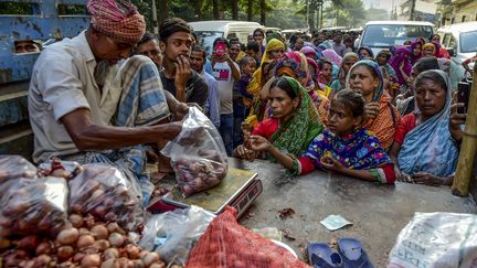 Au Bangladesh, la population fait la queue pour obtenir des oignons alors que les prix ont flambé. (MUNIR UZ ZAMAN / AFP)