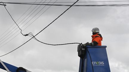 Un employé d'Enedis répare un fil électrique après le passage de la tempête Ciaran à Lanildut (Finistère), le 2 novembre 2023. (DAMIEN MEYER / AFP)