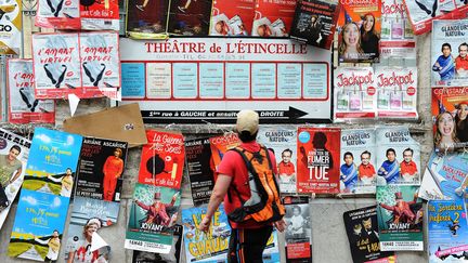 Un passant devant les affiches de la 70ème édition du festival d'Avignon, en 2016.&nbsp; (FERNAND FOURCADE/SIPA)