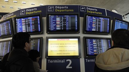 Des passagers surveillent le tableau des d&eacute;parts, &agrave; l'a&eacute;roport de Roissy, pendant une gr&egrave;ve des pilotes et du personnel navigant, le 6 f&eacute;vrier 2012. (BERTRAND GUAY / AFP)