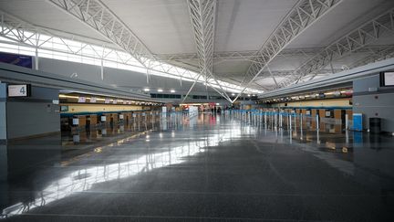 Des&nbsp;comptoirs d'enregistrement vides, à l'aéroport international&nbsp;John-F.-Kennedy, à New York (Etats-Unis), le 13 mars 2020, en pleine pandémie de Covid-19.&nbsp; (TAYFUN COSKUN / ANADOLU AGENCY / AFP)