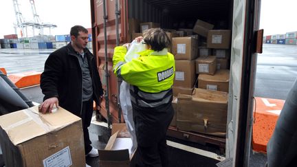 Une douani&egrave;re du port du Havre (Seine-Maritime) effectue le contr&ocirc;le d'un conteneur, le 20 janvier 2009 au Havre. (ROBERT FRANCOIS / AFP)