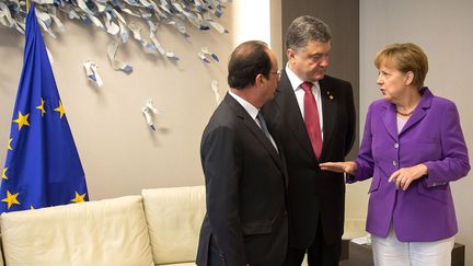 Fran&ccedil;ois Hollande (G.),&nbsp;Petro Porochenko et&nbsp;Angela Merkel, lors d'une rencontre &agrave; Bruxelles (Belgique), le 27 juin 2014. (GUIDO BERGMANN / DPA / AFP)