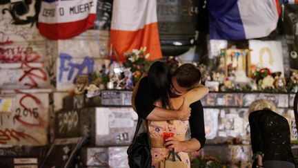 Des personnes se serrent dans les bras sur la place de la République, le 26 juillet 2016. (GEOFFROY VAN DER HASSELT / AFP)