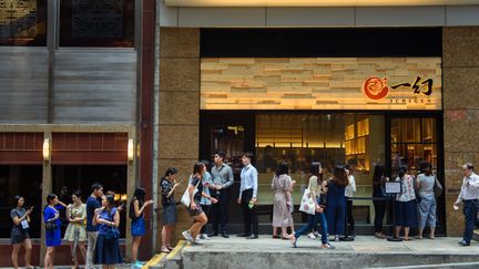 Des personnes font la queue devant un restaurant à l'heure de la pause déjeuner, à Hong Kong, le 16 août 2019. (GREGOR FISCHER / DPA / AFP)