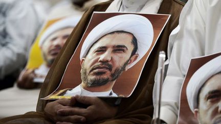 Portraits de Cheikh Ali Salman, chef du mouvement chiite d'opposition bahreïnie, Al-Wefaq (dissous), brandis lors d'une manifestation contre son arrestation, le 26 mai 2016 à Manama. (STRINGER/AFP)