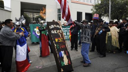 Des manifestants br&ucirc;lent un drapeau am&eacute;ricain et un cimeti&egrave;re sur lequel figure les drapeaux de l'Espagne, de la France, de l'Italie et du Portugal, lundi 8 juillet &agrave; La Paz (Bolivie). (JORGE BERNAL / AFP)