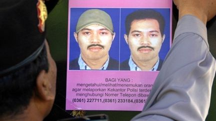 Un policier affiche un avis de recherche de Noordin Top, l'homme le plus recherché d'Indonésie (juillet 2009) (© AFP / Sonny Tumbelaka)