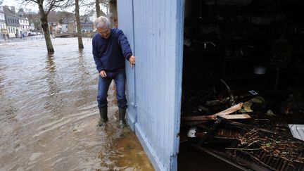 Un habitant de Quimperl&eacute; (Finist&egrave;re) nettoie l'entr&eacute;e de son domicile apr&egrave;s les crues, le 3 janvier 2014. (FRED TANNEAU / AFP)