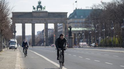 Des cyclistes devant la porte de Brandebourg à Berlin (Allemagne). Photo d'illustration. (ODD ANDERSEN / AFP)