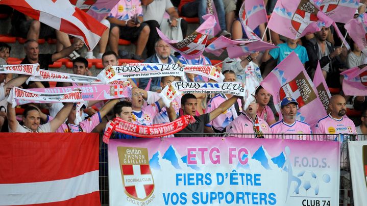 Les supporters d'Evian Thonon Gaillard, lors d'un match contre Bordeaux, le 11 ao&ucirc;t 2012. On voit bien la r&eacute;sistance des couleurs rouges et blanches historiques du club, ainsi que du nom "Croix de Savoie". (JEAN-PIERRE CLATOT / AFP)