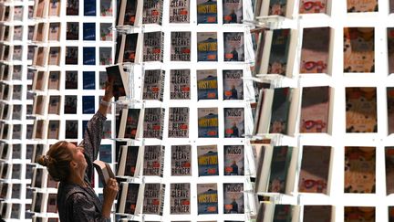 Une membre du personnel de la Foire du livre de Francfort&nbsp;aménage le stand de l'éditeur&nbsp;Piper Verlag (19 octobre 2021) (ARNE DEDERT / DPA / AFP)