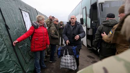 Des Ukrainiens sortent d'un bus lors d'un échange de prisonniers entre l'Ukraine et les séparatistes pro-russes près du poste de contrôle de Mayorsk, le 29 décembre 2019. (HO / UKRAINIAN PRESIDENTIAL PRESS SERVICE / AFP)