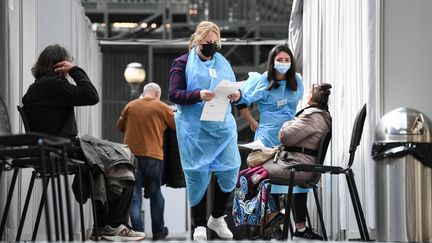 Des soignants discutent avec des patients avec leur vaccination contre le Covid-19, dans un centre&nbsp;du 19e arrondissement de Paris, en avril 2021. (ALAIN JOCARD / AFP)