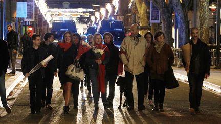 Manifestation d'une vingtaine de "foulards rouges", groupe d'opposition aux "gilets jaunes", rue de la République où ils déposent des fleurs blanches, le 7 décembre 2018. (SOUILLARD BRUNO / MAXPPP)