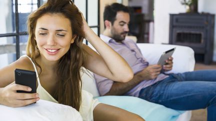 Un couple utilise un téléphone et une tablette le 27 janvier 2016. (FR?D?RIC CIROU / ALTOPRESS)