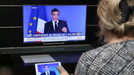 Une femme regarde la conférence de presse de François Fillon à la télévision, le lundi 6 février 2017. (JEAN-FRANCOIS FREY / MAXPPP)