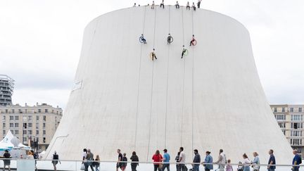 Descente en rappel sur le Volcan, comme on appelle le bâtiment qui abrite la Scène nationale du Havre (Seine-Maritime), le 5 juillet. (FLORA ELIE / HANS LUCAS / AFP)