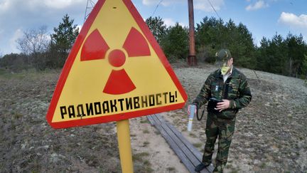 Un homme mesure les radiations dans la zone d'exclusion de Tchernobyl en Biélorussie. (VIKTOR TOLOCHKO / RIA NOVOSTI)