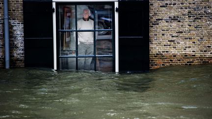 Un Hollandais regarde l'eau monter de sa maison &agrave; Dordrecht (Pays-Bas), le 5 janvier 2011. (ROBIN UTRECHT / AFP)