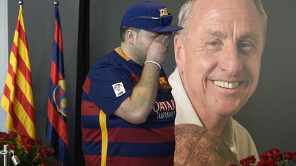 Un supporter du Barça, en larmes devant la photo de Cruyff.  (LLUIS GENE / AFP)