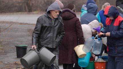 Des habitants attendent pour remplir des récipients d'eau dans la région de Marioupol le 1er mars 2022. (IVAN RODIONOV / SPUTNIK)