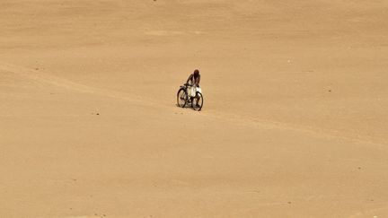 Un villageois pousse son v&eacute;lo sur les rives de la rivi&egrave;res&nbsp;Kuakhai (Inde) alors que la temp&eacute;rature d&eacute;passe les 37&deg;C, le 9 juin 2014. (REUTERS)