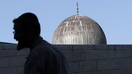 Un rabbin ultra-orthodoxe, qui r&eacute;clame le droit de prier sur l'Esplanade des mosqu&eacute;es, passe deant le dome de la mosqu&eacute;e Al-Aqsa, &agrave; J&eacute;rusalem, le 14 juillet 2015. (AHMAD GHARABLI / AFP)