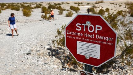 Un panneau signalant la dangerosité de marcher en cas de températures très élevées, le 9 juillet 2024 dans la Vallée de la mort, en Californie. (MARIO TAMA / GETTY IMAGES NORTH AMERICA / AFP)