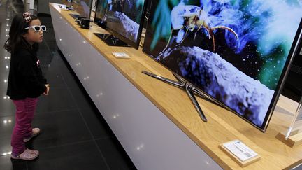 Une petite fille regarde un &eacute;cran 3D dans un magasin Samsung, le 28 octobre 2011, &agrave; S&eacute;oul (Cor&eacute;e du Sud). (JO YONG HAK / REUTERS)