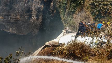 Les secours autour de l'épave de l'avion qui s'est écrasé à Pokhara (Népal), le 15 janvier 2023. (BISHAN CHETRI / ANADOLU AGENCY / AFP)