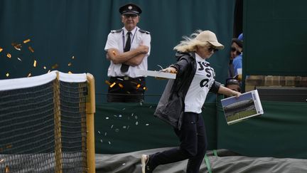 Une militante de "Just Stop Oil" s'introduisant sur le court numéro 18 de Wimbledon, le 5 juillet 2023. (ALASTAIR GRANT / SIPA)