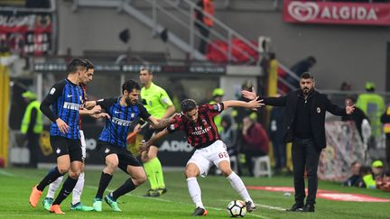 Ricardo Rodriguez (AC Milan) aux prises avec Antonio Candreva (Inter Milan) sous les yeux du coach Gennaro Gattuso (MIGUEL MEDINA / AFP)