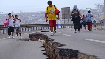 Des passants constatent les d&eacute;g&acirc;ts d'un tremblement de terre, le 2 avril 2014, &agrave; Iquique (Chili). (ALDO SOLIMANO / AFP)