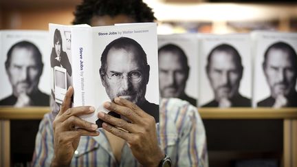 Un lecteur britannique feuillette la biographie officielle de Steve Jobs, &eacute;crite par Walter Isaacson, le 24 octobre, &agrave; Londres.&nbsp; (POHLE / THE TIMES / SIPA)